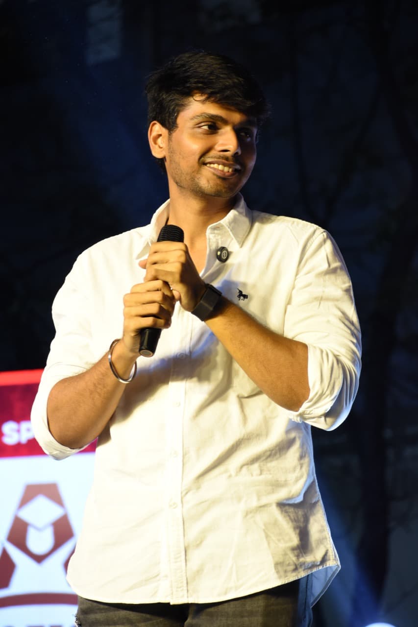 GM Akash Ganesan speaking on stage at a public event